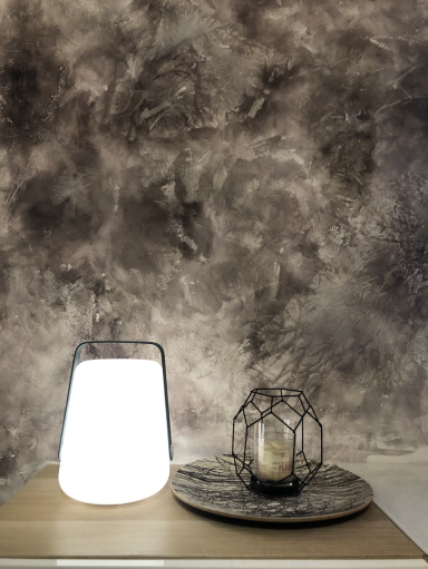 Lampe #Formob et bougeoir sur une table avec un fond mural texturé.