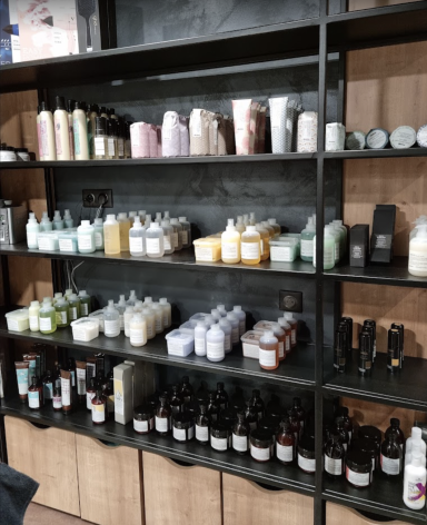 Produits de beauté et soins alignés sur des étagères noires.