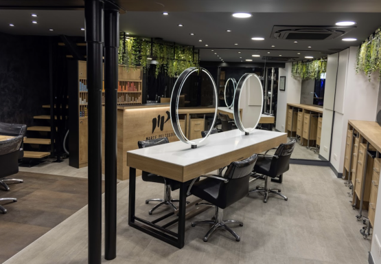 Espace de salon de coiffure moderne avec miroirs et chaises élégantes.