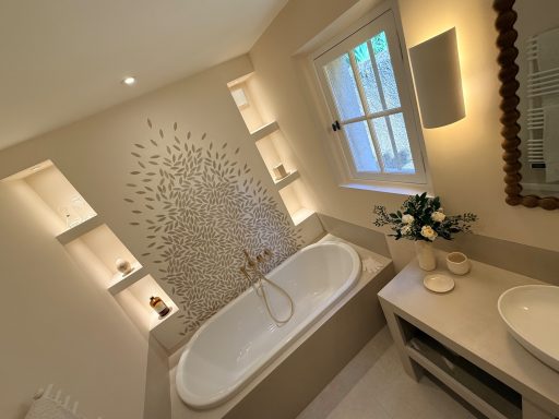 Salle de bain Seillan, Var Salle de bain élégante avec baignoire, éclairage doux et étagères intégrées.