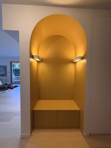 Entrée cosy avec arche et banc et des appliques lumineuses.
