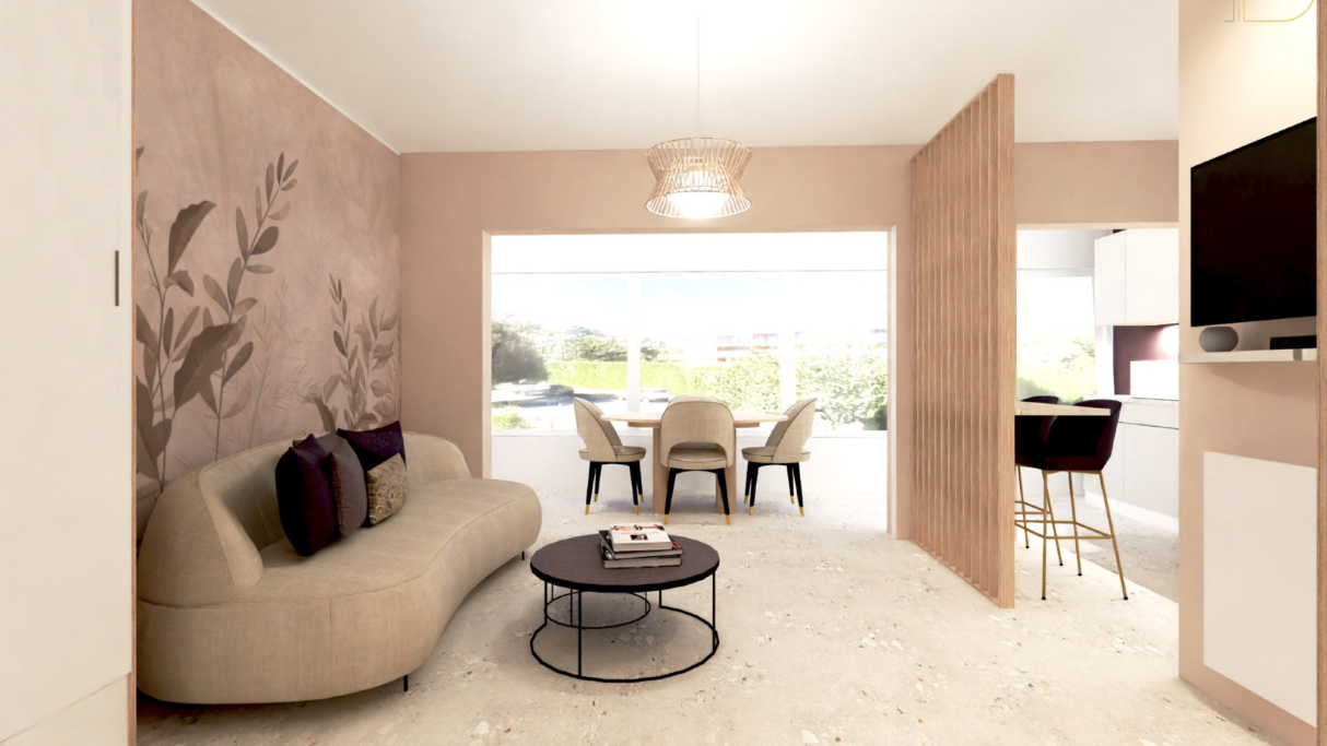 Studio Mandelieu Salon moderne avec canapé, table basse, et salle à manger lumineuse. Mur décoré de motifs floraux.