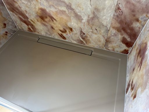 Douche avec feuille de pierre Slate Lite et receveur beige.